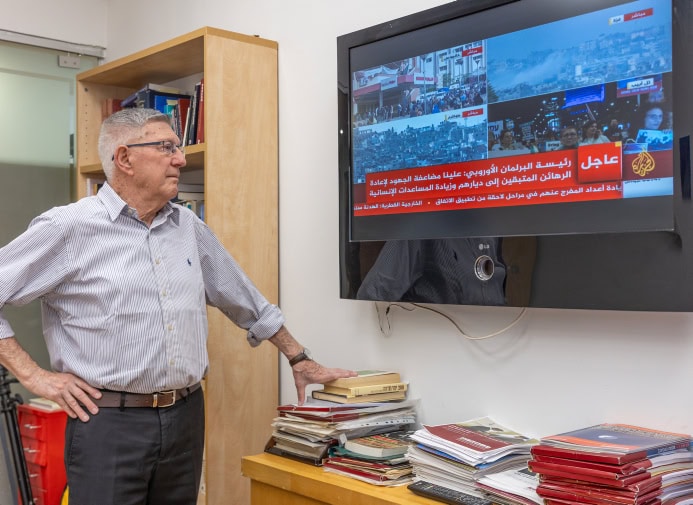 יגאל כרמון, ראש מכון המחקר ממר"י, צופה בשידורי "אל-ג'זירה" (צילום: יוסי אלוני)