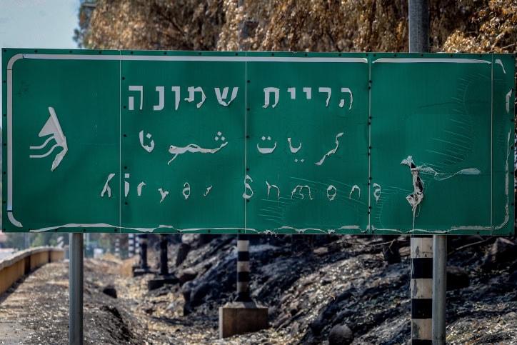 שלט בכניסה לקריית שמונה, שעוות בשריפה מירי טילים מלבנון, 4.6.2024 (צילום: דוד כהן)