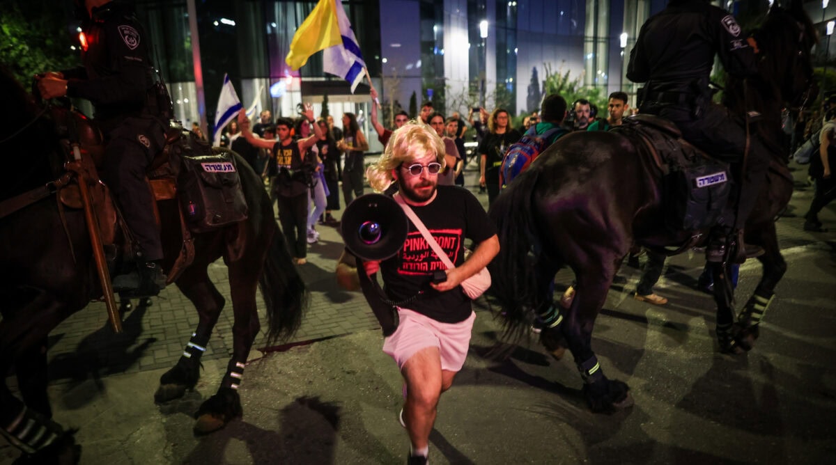 מפגין שועט בין סוסי משטרה, בהפגנה למען החזרת החטופים מרצועת עזה. תל-אביב, 27.3.2025 (צילום: איתי רון) מפגין שועט בין סוסי משטרה, בהפגנה למען החזרת החטופים מרצועת עזה. תל-אביב, 27.3.2025 (צילום: איתי רון)