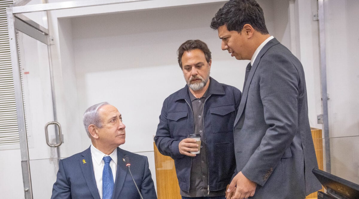בנימין נתניהו עם סנגורו, עו"ד עמית חדד, והדובר עופר גולן, בפתח יום עדותו ה-20 במשפטו הפלילי. בית המשפט המחוזי בתל-אביב, 31.3.2025 (צילום: מרים אלסטר)