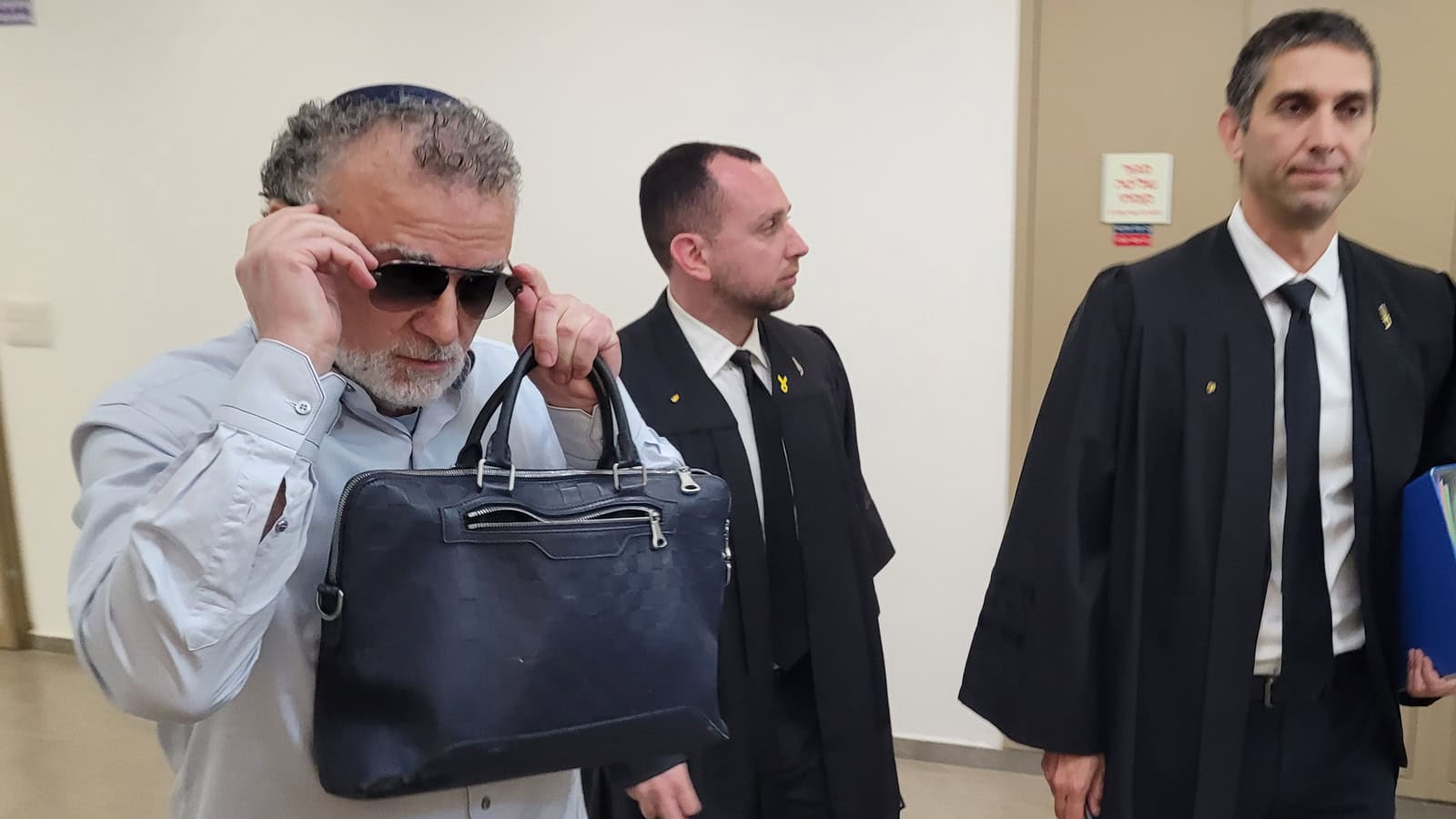 מיכאל מירילשוילי בבית המשפט המחוזי בתל-אביב, יולי 2025. ברקע: עורכי דינו תומר ויסמן (מימין) ואילן שטרנברג (צילום: איתמר ב"ז) מיכאל מירילשוילי בבית המשפט המחוזי בתל-אביב, יולי 2025. ברקע: עורכי דינו תומר ויסמן (מימין) ואילן שטרנברג (צילום: איתמר ב"ז)