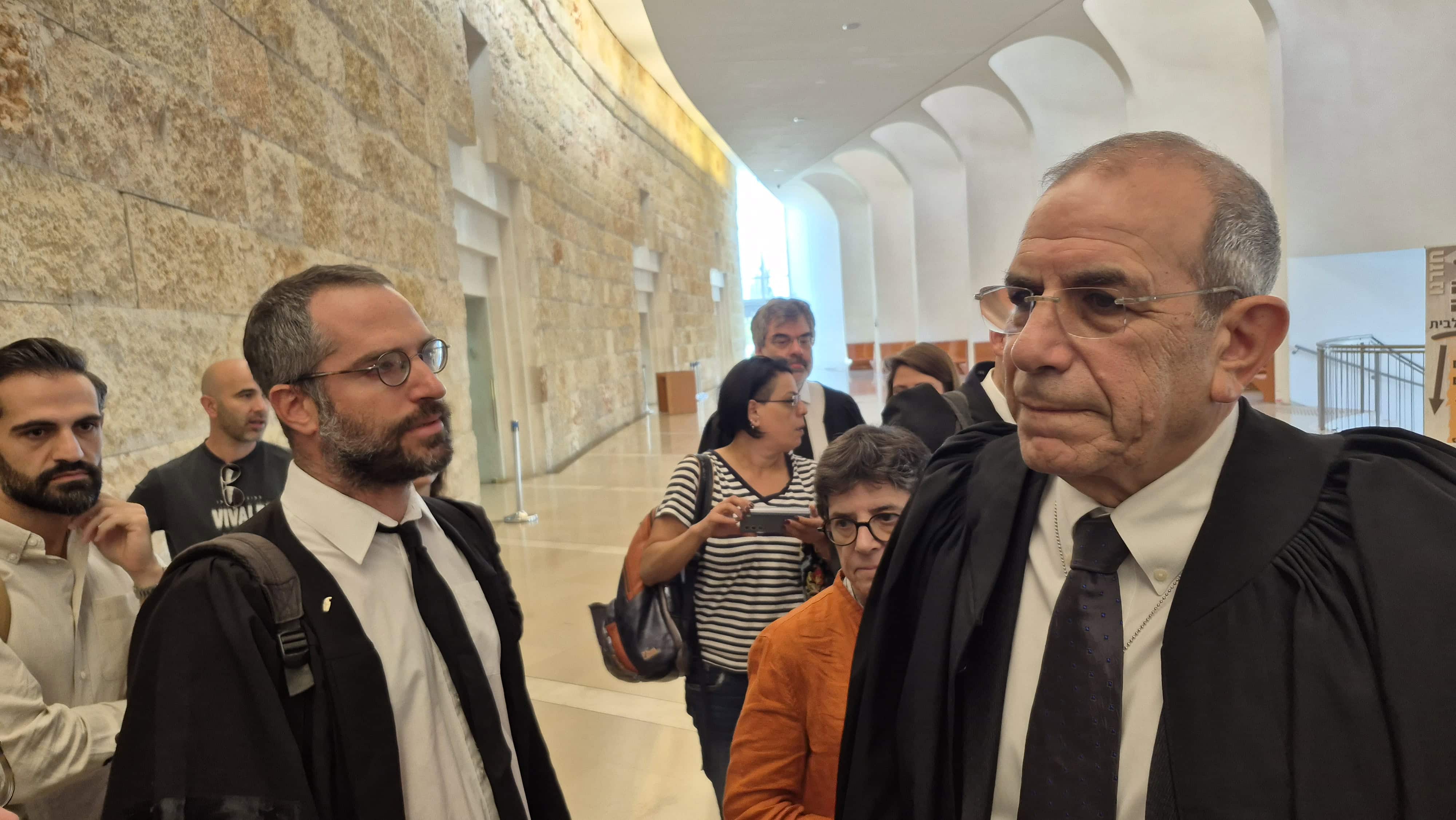 עו"ד גלעד שר (מימין), בא כוח התאחדות העיתונאים הזרים ועו"ד יהונתן נד"ב (משמאל), בא כוח המדינה, בצאתם מהדיון על העתירה לכניסת עיתונאים זרים לעזה, בית המשפט העליון, 23.10.25 (צילום: אורן פרסיקו)