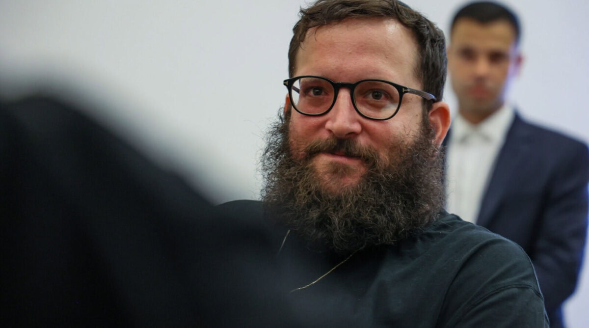 יונתן אוריך, יועץ נתניהו החשוד בפרשת קטאר ובפרשת המסמכים, בדיון הארכת מעצר בביהמ"ש בלוד, 19.8.25 (צילום: יונתן שאול)