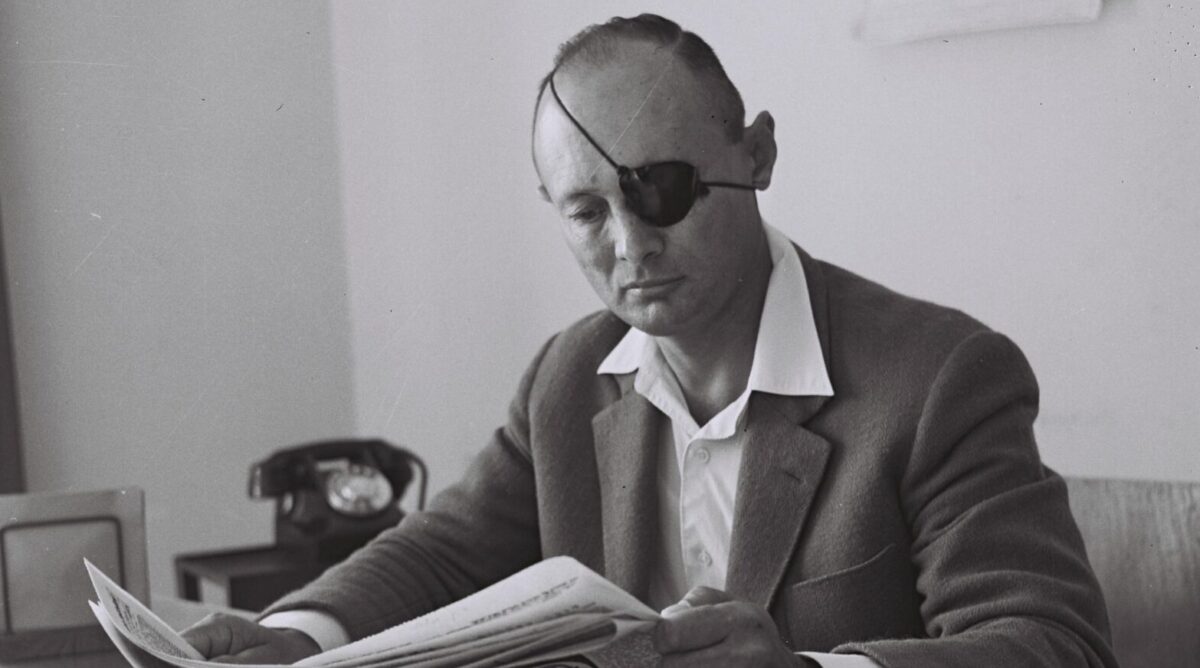 משה דיין קורא עיתון, 1959 (צילום: פריץ כהן, לע"מ)