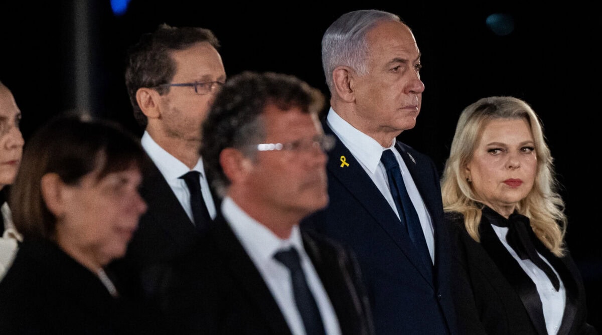 נשיא בית המשפט העליון יצחק עמית עם אשתו רבקה. ברקע: רה"מ הנאשם בנימין נתניהו עם אשתו שרה (מימין) ונשיא המדינה יצחק הרצוג עם אשתו מיכל; טקס יום הזיכרון, כנסת ישראל, 29.4.25 (צילום: יונתן זינדל)