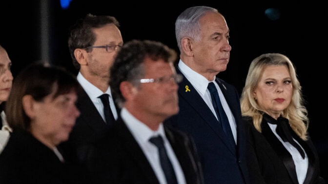 נשיא בית המשפט העליון יצחק עמית עם אשתו רבקה. ברקע: רה"מ הנאשם בנימין נתניהו עם אשתו שרה (מימין) ונשיא המדינה יצחק הרצוג עם אשתו מיכל; טקס יום הזיכרון, כנסת ישראל, 29.4.25 (צילום: יונתן זינדל)