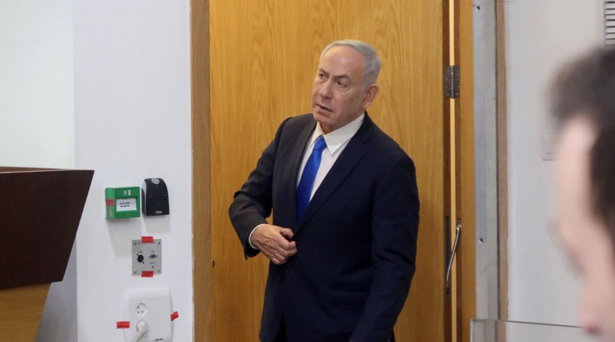 ראש הממשלה בנימין נתניהו מציץ לאולם משפט המו"לים בתל-אביב כדי לבדוק אם השופטים כבר נכנסו בתום הפסקה ביום עדותו ה-96. 22.6.2026 (צילום: אורן פרסיקו)