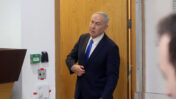 ראש הממשלה בנימין נתניהו מציץ לאולם משפט המו"לים בתל-אביב כדי לבדוק אם השופטים כבר נכנסו בתום הפסקה ביום עדותו ה-96. 22.6.2026 (צילום: אורן פרסיקו)