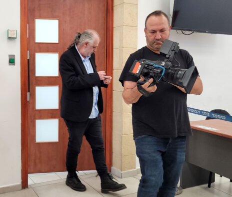 צלם ערוץ 14 משה קדוש באולם משפט המו"לים (מאחור: העד אמיר ברקן). בית המשפט המחוזי בירושלים, 8.7.2026 (צילום: איתמר ב"ז)