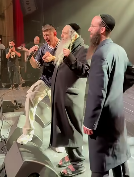צילום מסך מסרטן שפורסם תחת הכיתוב "הסרטון המלא! הרב שלום ארוש שליטא הרב יהושע מרגלית שליטא הזמר ששון איפרם שאולוב בקידוש ה׳ מטורףף!!!!"